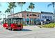 Street view of 'Sarasota Trolley' near shops and restaurants with palm trees lining the street under blue skies at 1604 Still River Dr, Venice, FL 34293
