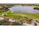 Expansive aerial view of a meticulously maintained golf course, featuring lush greens, mature trees, and a scenic lake at 181 Portofino Dr, North Venice, FL 34275