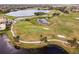 Picturesque aerial shot of a golf course with lush greens, shimmering lakes, and meticulously maintained fairways for play at 181 Portofino Dr, North Venice, FL 34275