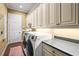 Functional laundry room with cabinetry, counter space, and modern appliances at 181 Portofino Dr, North Venice, FL 34275