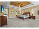 Spacious main bedroom featuring tray ceilings, plush carpet, a ceiling fan, and ample natural light for a relaxing retreat at 181 Portofino Dr, North Venice, FL 34275