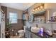 Modern bathroom with gray tile, an illuminated mirror, and a stylish vanity, providing a sleek and comfortable space at 2130 Temple St, Sarasota, FL 34239