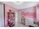 Spacious pink bedroom featuring a dresser, changing table, and decor, creating a playful and functional space at 2130 Temple St, Sarasota, FL 34239