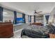 Comfortable bedroom with a tv, ceiling fan, and natural light from multiple windows with blue curtains at 2130 Temple St, Sarasota, FL 34239