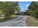 Exterior view of the home with a long gravel driveway and mature trees at 2130 Temple St, Sarasota, FL 34239