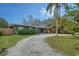 Beautiful single-story home featuring manicured landscaping and a gravel driveway leading to the entrance at 2130 Temple St, Sarasota, FL 34239
