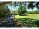 A paved path in Arlington Park with lampposts and lush green space, perfect for walking and recreation at 2130 Temple St, Sarasota, FL 34239