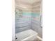 Modern bathroom features tiled walls, a shower-tub combination, and a glass panel for a bright, clean look at 2180 Orchid St, Sarasota, FL 34239