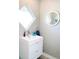 This bathroom offers a modern vanity and sink, accompanied by a round mirror and unique square window design at 2180 Orchid St, Sarasota, FL 34239