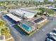 Aerial view showcasing an in-ground screened pool, solar panels, and ample parking at 2395 Harbor Blvd # 322, Port Charlotte, FL 33952