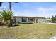 Well-maintained single-story home with green lawn, palm tree, and black shutters at 2428 Linwood Dr, Sarasota, FL 34232