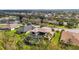 Aerial view of a house with a screened-in pool surrounded by lush greenery in a residential neighborhood at 2515 130Th E Ave, Parrish, FL 34219
