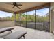 A covered balcony with lounge chairs overlooks the lush backyard at 2515 130Th E Ave, Parrish, FL 34219
