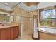 Bathroom featuring a glass enclosed shower, soaking tub, and marble topped vanity at 2515 130Th E Ave, Parrish, FL 34219
