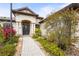 Front entrance of a stucco home featuring a decorative front door and meticulously manicured landscaping at 2515 130Th E Ave, Parrish, FL 34219