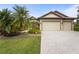 Charming single-story home with a three car garage, tropical landscaping, and a brick paved driveway at 2515 130Th E Ave, Parrish, FL 34219