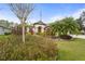 Landscaped front yard featuring an American flag, palm tree, and a view of the home's entrance at 2515 130Th E Ave, Parrish, FL 34219