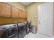 Well-equipped laundry room with washer, dryer, storage cabinets, and tiled floor at 2515 130Th E Ave, Parrish, FL 34219