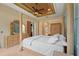 Luxurious main bedroom featuring a tray ceiling, four-poster bed, and elegant furnishings at 2515 130Th E Ave, Parrish, FL 34219
