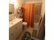 Clean bathroom featuring a vanity, toilet, and shower with orange curtain at 2696 Loma Linda St, Sarasota, FL 34239