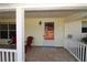 Inviting front porch with tile flooring, seating, and a freshly painted entrance door at 2696 Loma Linda St, Sarasota, FL 34239