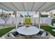 Outdoor entertaining area with dining table, lush landscaping, and shaded pergola at 309 Avenida Milano, Sarasota, FL 34242