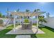 Charming backyard patio featuring a pergola-covered dining area with lush green surroundings, and a modern aesthetic at 309 Avenida Milano, Sarasota, FL 34242