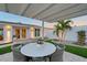 Cozy outdoor dining under a stylish pergola, complemented by beautiful landscaping at 309 Avenida Milano, Sarasota, FL 34242