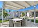 Cozy backyard patio with a pergola, dining set, and manicured lawn offering a serene outdoor living space at 309 Avenida Milano, Sarasota, FL 34242
