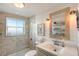 Bright bathroom with shower, shiplap accent wall, and framed mirror at 309 Avenida Milano, Sarasota, FL 34242