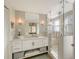 Modern bathroom with bright white vanity, a large mirror, and glass enclosed shower at 309 Avenida Milano, Sarasota, FL 34242