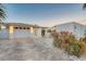 Wide brick paver driveway leads to a well-lit garage with a meticulously landscaped yard at 309 Avenida Milano, Sarasota, FL 34242