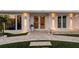 Elegant home entrance with double glass doors, decorative urns, and a paved walkway at 309 Avenida Milano, Sarasota, FL 34242