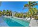Stunning pool area with a sun-shelf, loungers, mature tropical landscaping, and a relaxing spa at 309 Avenida Milano, Sarasota, FL 34242