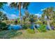 Scenic backyard with mature trees, lush grass, and a pond at 3335 Brooklyn Ave, Port Charlotte, FL 33952