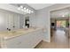 Bathroom with double sinks, large mirror, and open doorway to living area and exterior patio at 3335 Brooklyn Ave, Port Charlotte, FL 33952