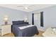 Bedroom with light blue walls, ceiling fan, and matching bedside lamps at 3335 Brooklyn Ave, Port Charlotte, FL 33952
