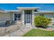 Inviting entryway with a screened-in porch, seating, and manicured landscaping at 3335 Brooklyn Ave, Port Charlotte, FL 33952