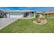 Well-maintained single-story home with attached garage, landscaping and a sprawling green lawn at 3335 Brooklyn Ave, Port Charlotte, FL 33952
