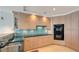 Bright kitchen featuring custom wood cabinetry, a blue backsplash, and stainless steel appliances at 35 Watergate Dr # 1101, Sarasota, FL 34236