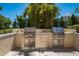 Outdoor stainless steel grill and built-in kitchen with palm tree backdrop at 35 Watergate Dr # 1101, Sarasota, FL 34236