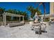 Outdoor seating and patio area with umbrellas and palm trees at 35 Watergate Dr # 1101, Sarasota, FL 34236
