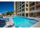 Beautiful pool and lounge area with clear blue water at a luxury high rise condo complex, surrounded by palm trees and city views at 35 Watergate Dr # 1101, Sarasota, FL 34236