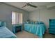 Bright bedroom featuring twin beds with blue quilted spreads, decorative pillows, and ceiling fan at 3658 Lake Bayshore Dr # 320, Bradenton, FL 34205