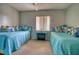 Cozy bedroom featuring two twin beds with blue quilted spreads and decorative pillows and a ceiling fan at 3658 Lake Bayshore Dr # 320, Bradenton, FL 34205