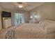 Cozy bedroom showcasing a queen bed, TV, white dresser, and access to the outdoor patio via sliding glass doors at 3658 Lake Bayshore Dr # 320, Bradenton, FL 34205