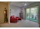 Cozy living room featuring a red armchair, ceiling fan, and sliding glass doors to the outdoor patio at 3658 Lake Bayshore Dr # 320, Bradenton, FL 34205