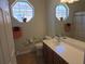 Well-lit bathroom with unique octagon-shaped windows, a vanity with cabinets, and floral decals at 3780 82Nd Avenue E Cir # 101, Sarasota, FL 34243