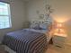 Comfortable bedroom with soft lighting, neutral colors, and floral accents on the wall at 3780 82Nd Avenue E Cir # 101, Sarasota, FL 34243