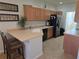 Kitchen featuring tan counters, wood cabinets and black appliances, complete with breakfast bar seating at 3780 82Nd Avenue E Cir # 101, Sarasota, FL 34243